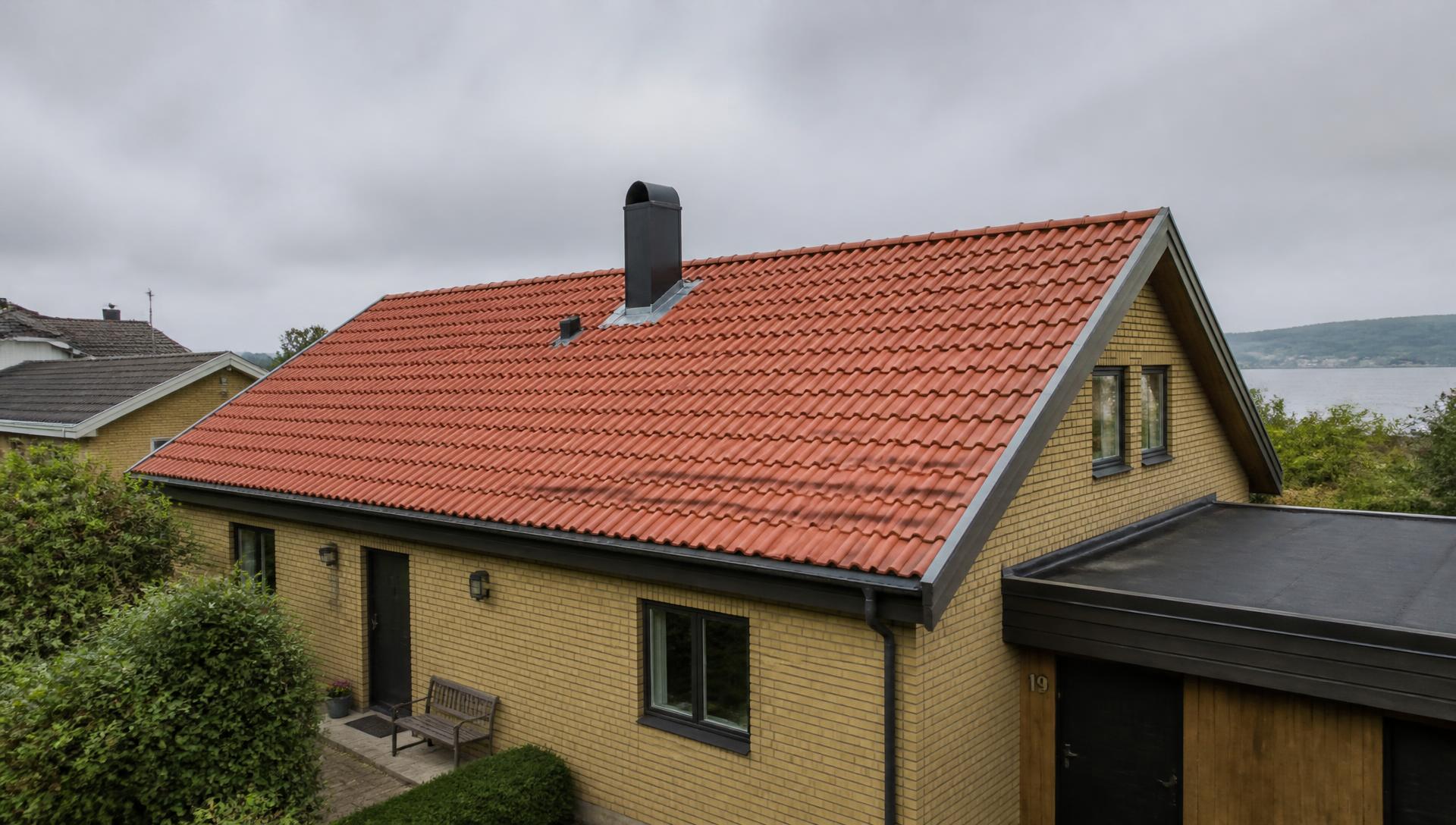 Villa i Jönköpingstrakten med nylagt tegeltak, skorsten och plåtdetaljer
