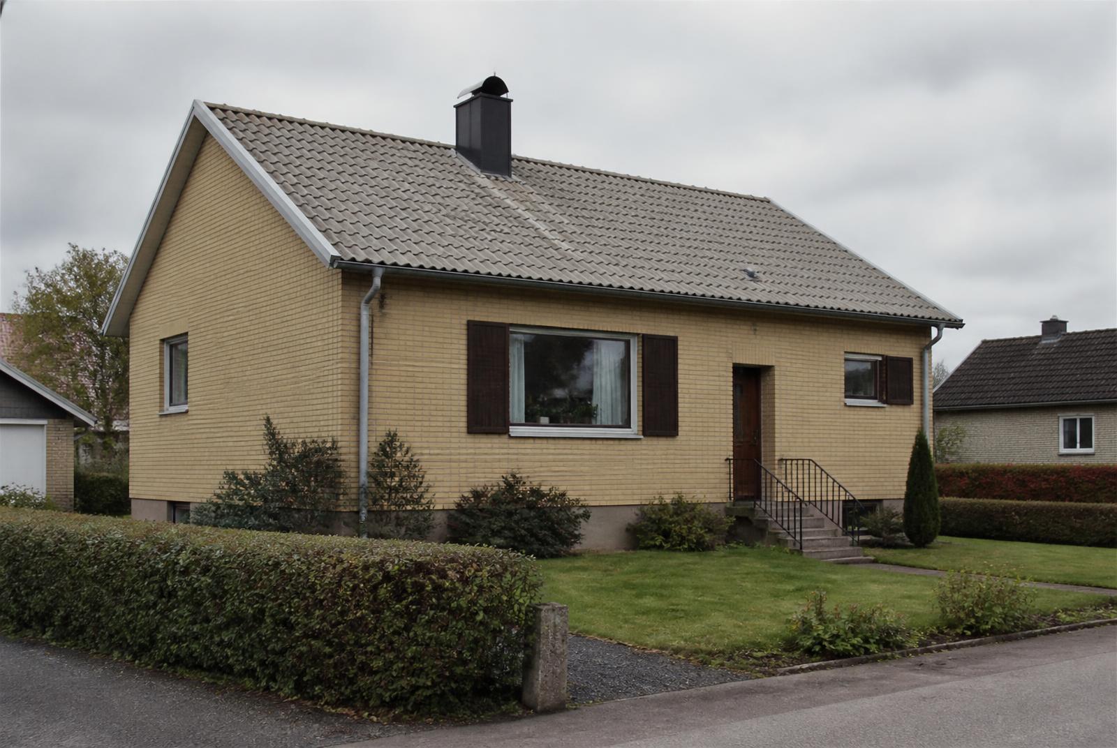 Svensk villa med betongpannor på taket, hängrännor och skorsten